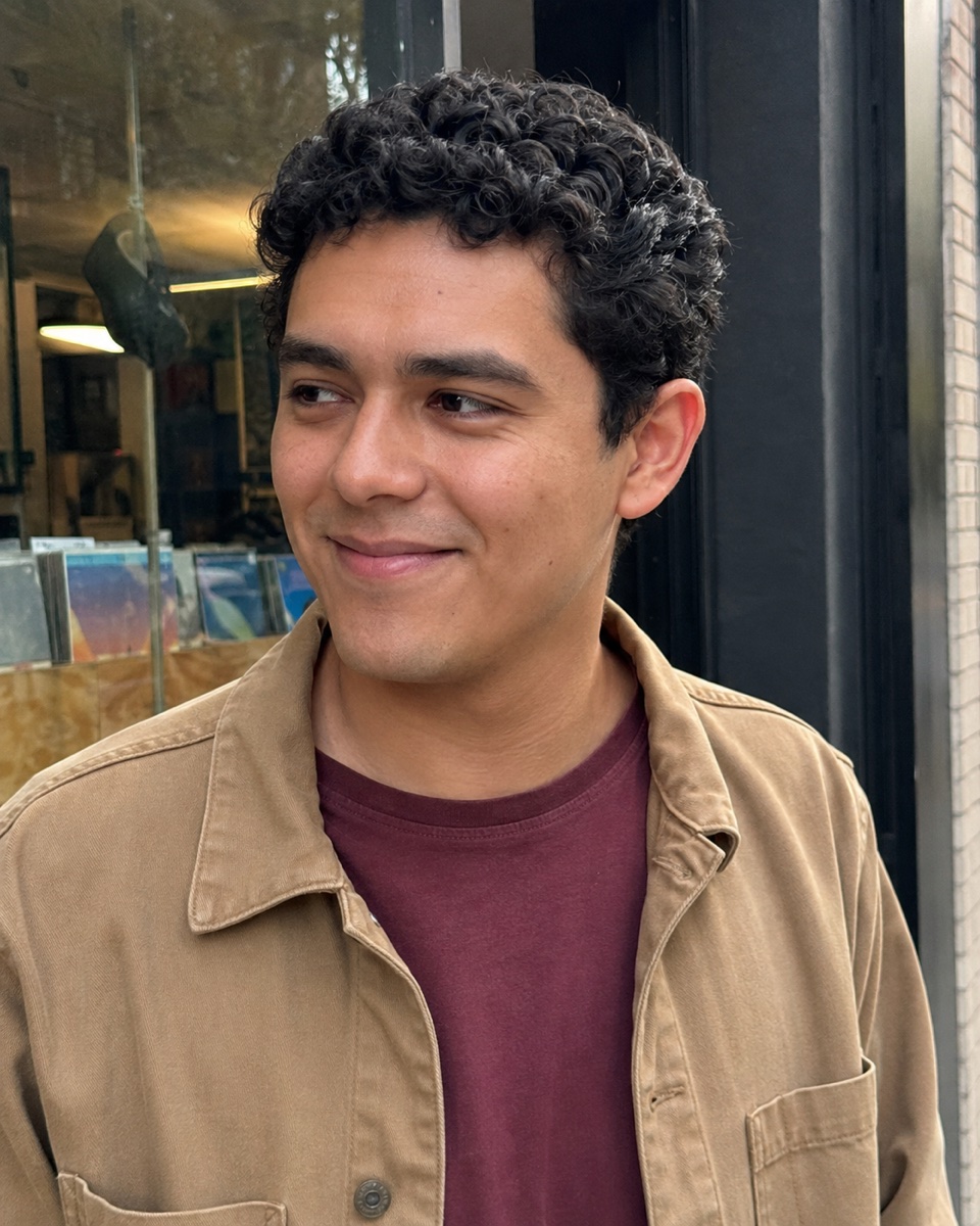 Mateo, a smiling Sift member outside a city shop